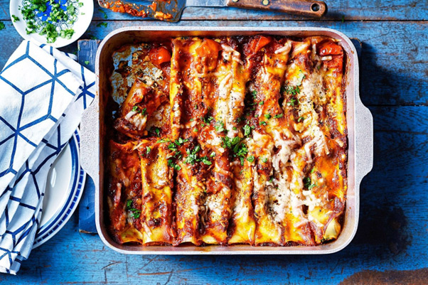 Ricotta and spinach canneloni with tomato sugo shown after removing from oven